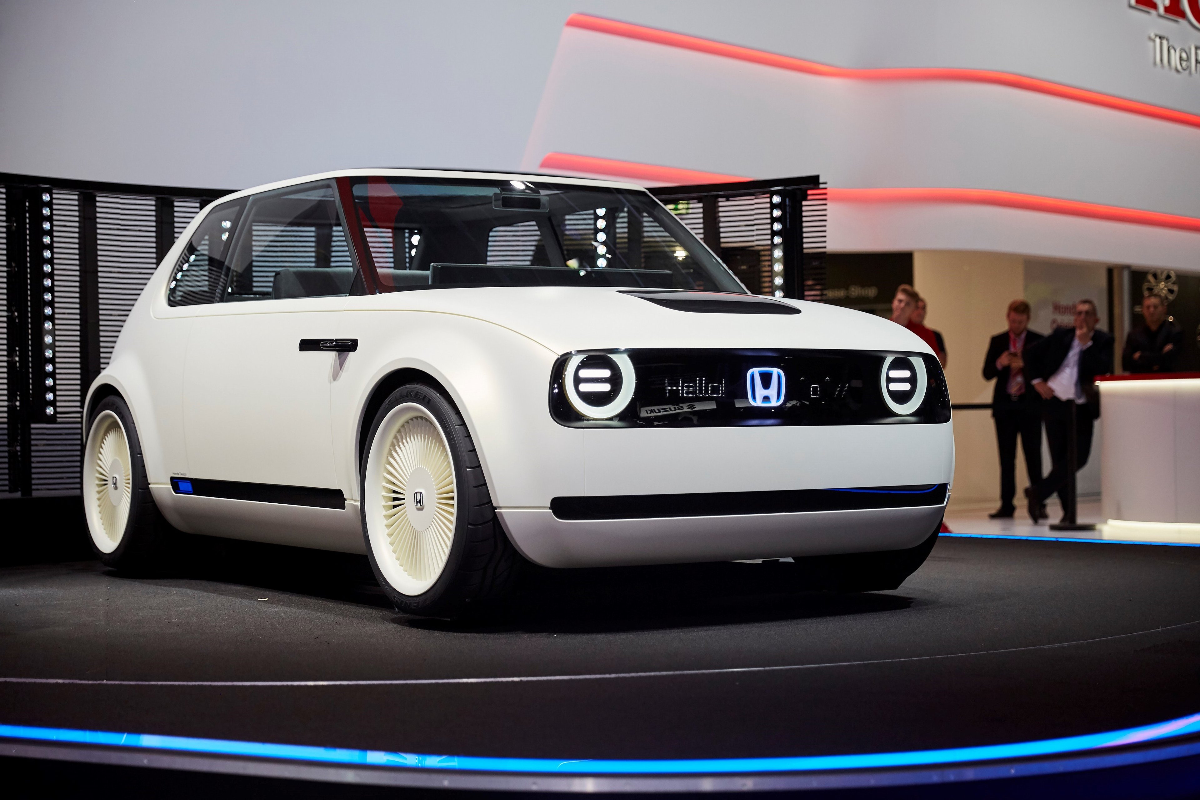 The Honda Urban EV Concept, a white hatchback with styling reminiscent of 1970s Honda Civics, on an auto-show stand.