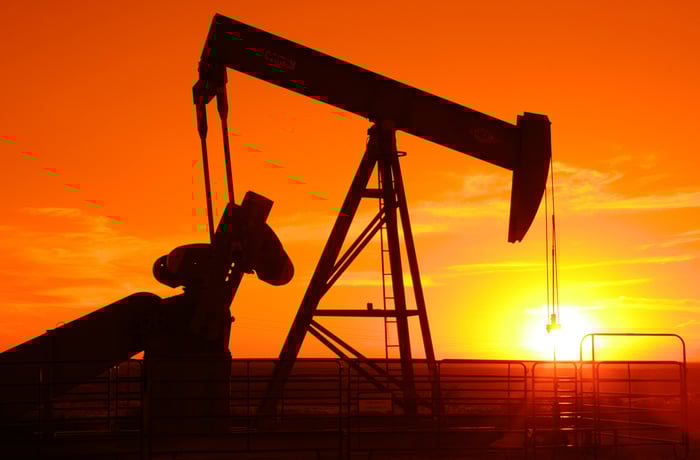 Pump jack with an orange sunset.