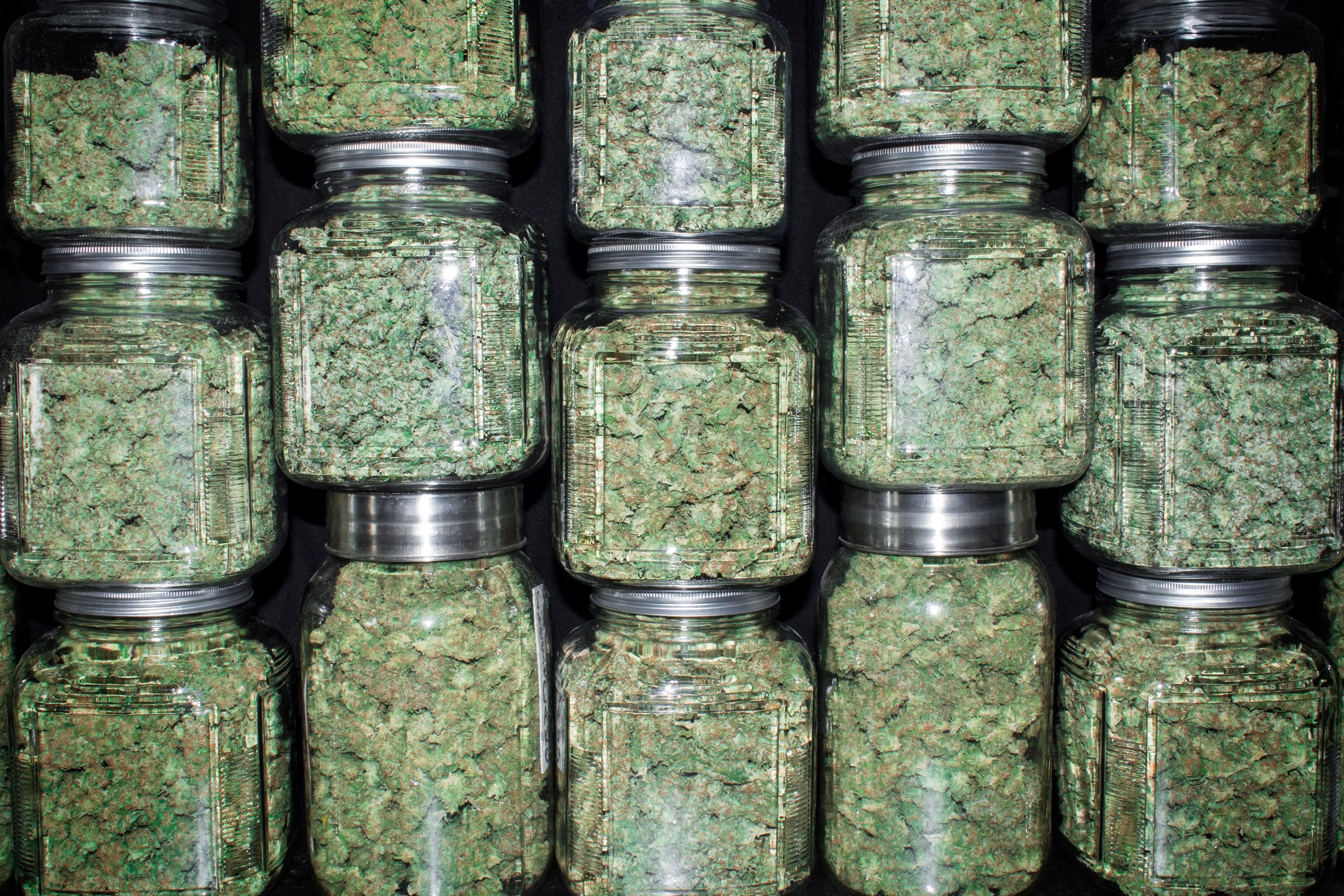 Jars filled with cannabis stacked on each other.