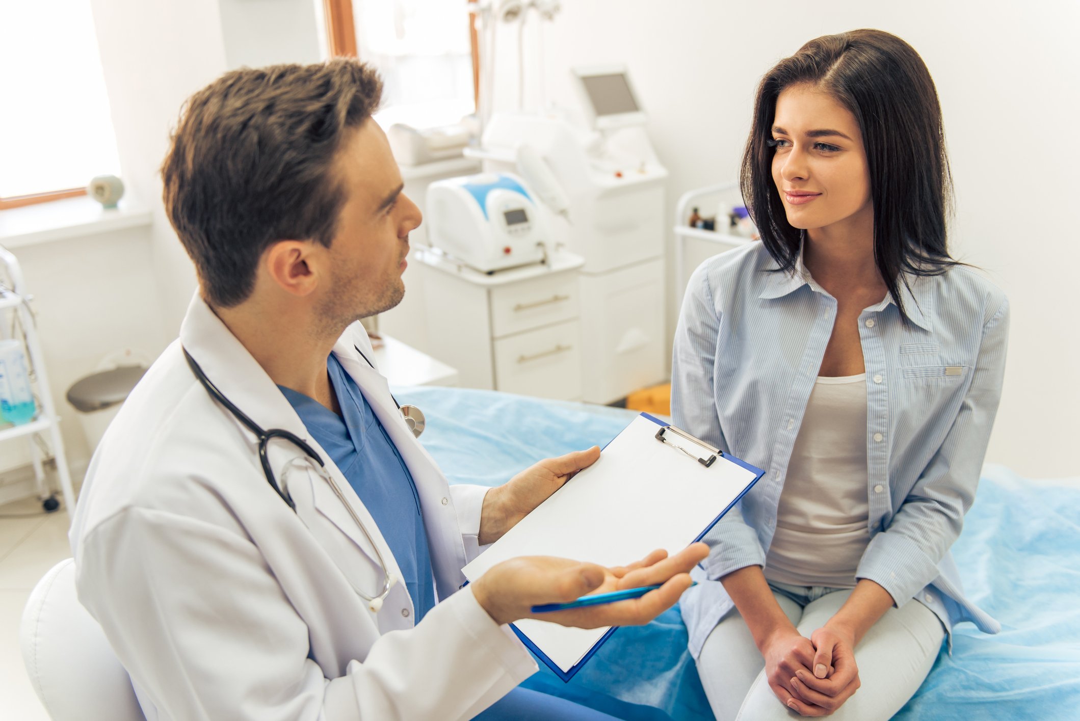 A doctor and a patient sit in discussion in an exam room.