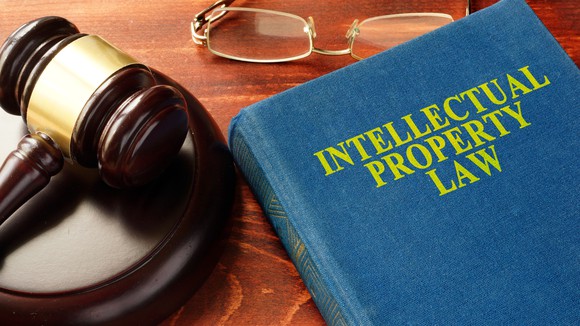 Intellectual property law book with a gavel on a table.