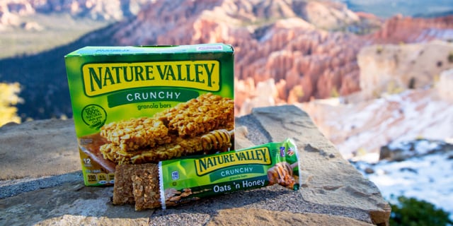 A box of Nature Valley granola bars with mountains in the background.