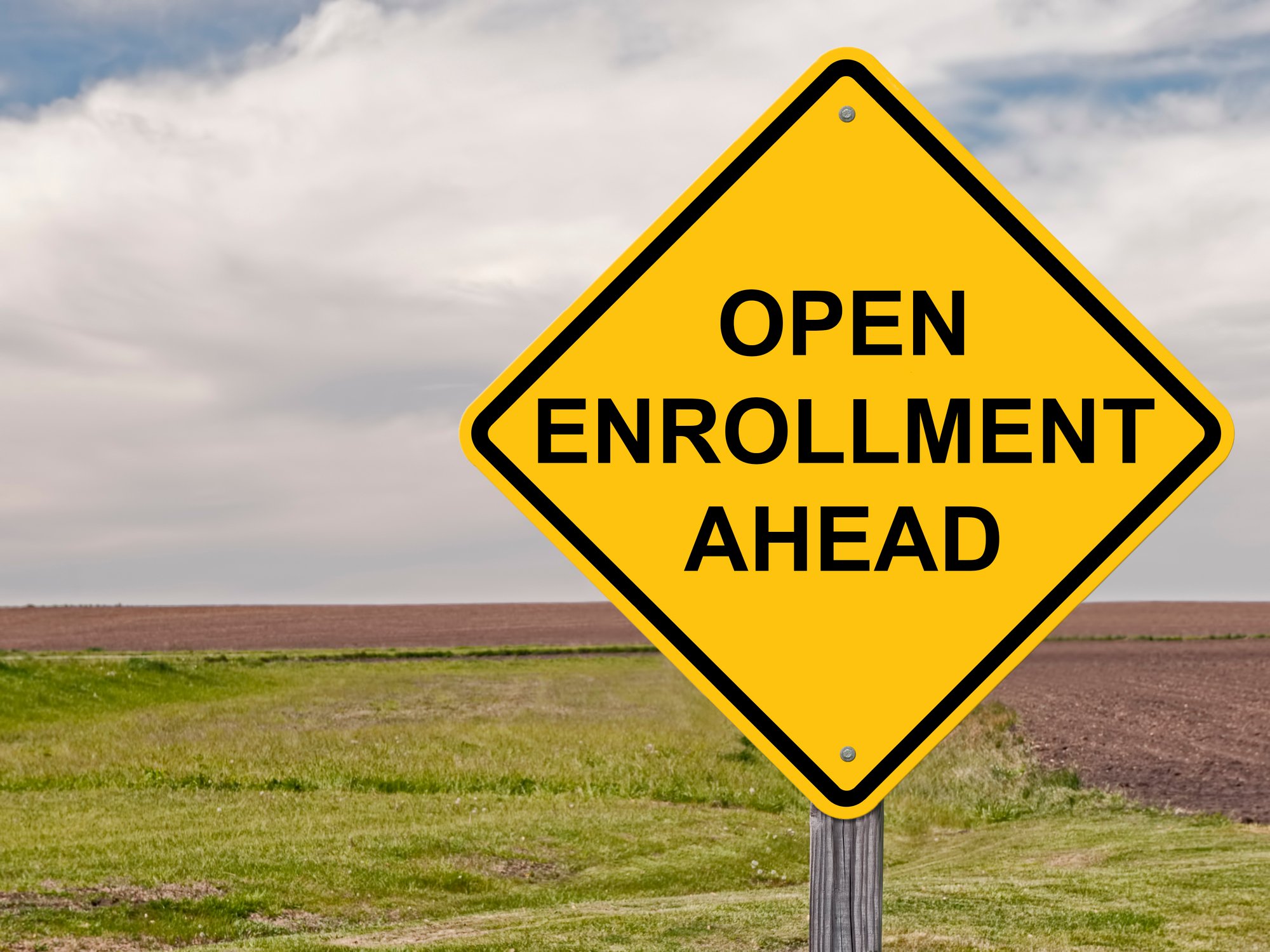 A road sign reads open enrollment ahead.