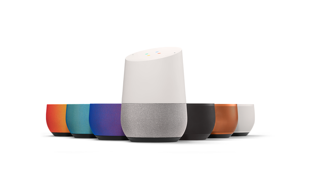 A Google Home alongside different colored, interchangeable bases.