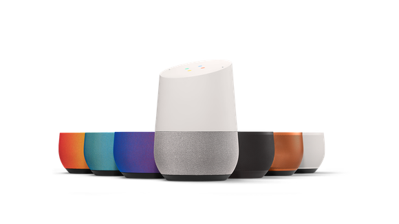 A Google Home alongside different colored, interchangeable bases.