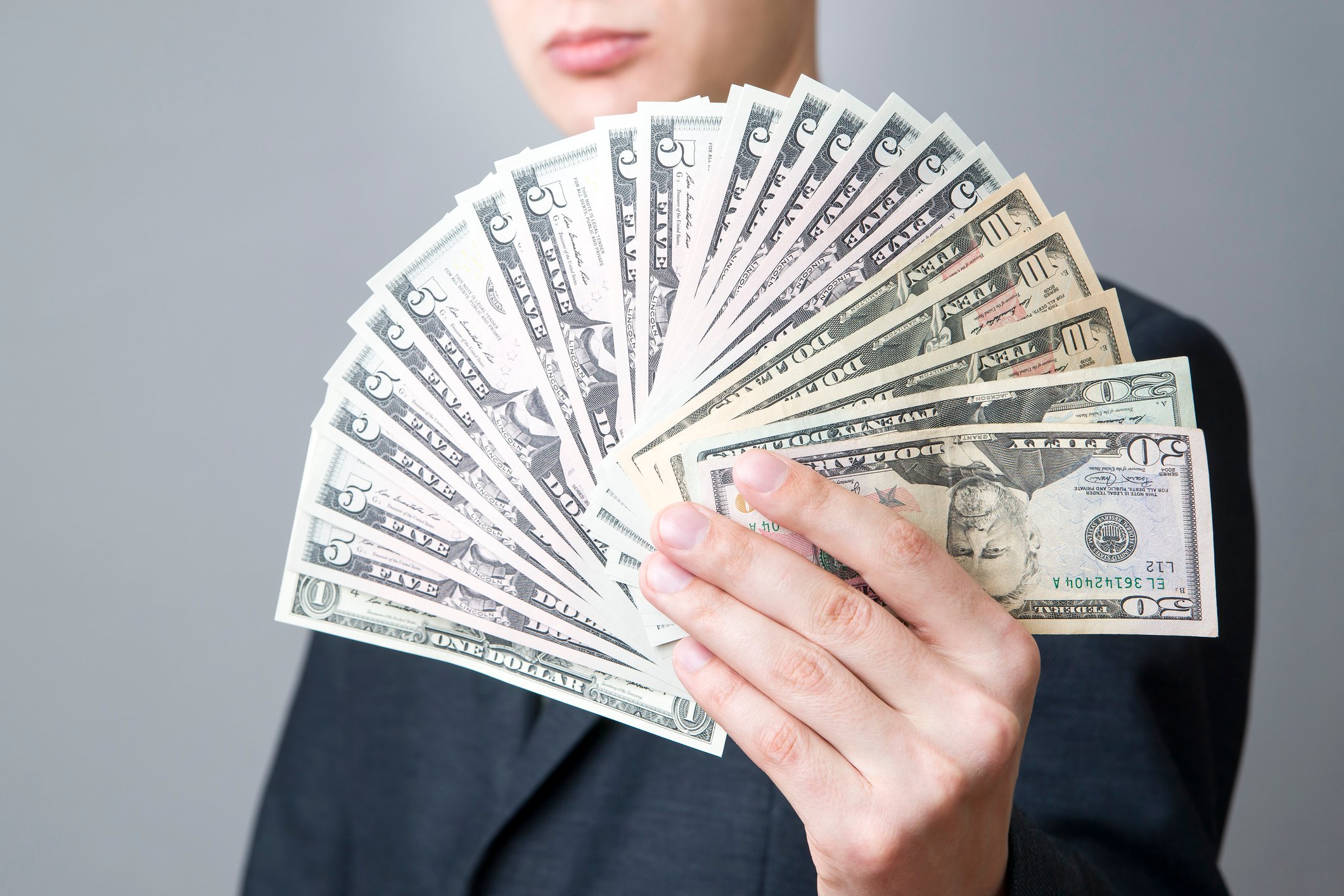 A man holding a fanned pile of dividend income.