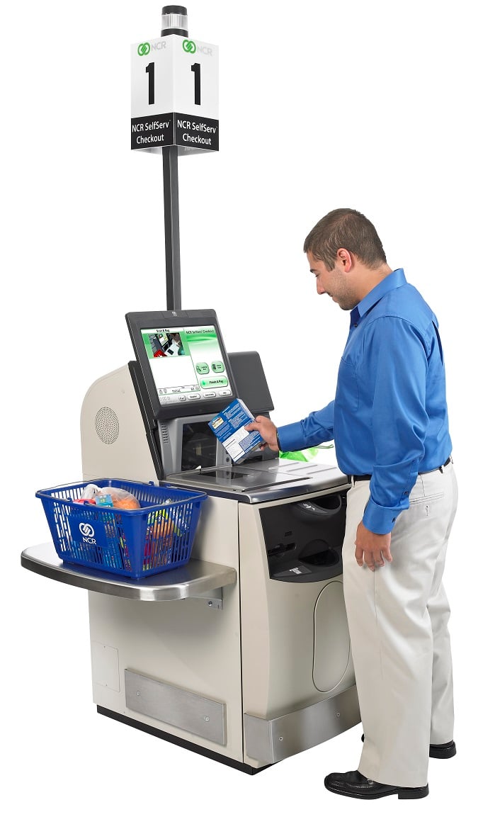 Person scanning groceries at a self-checkout kiosk.