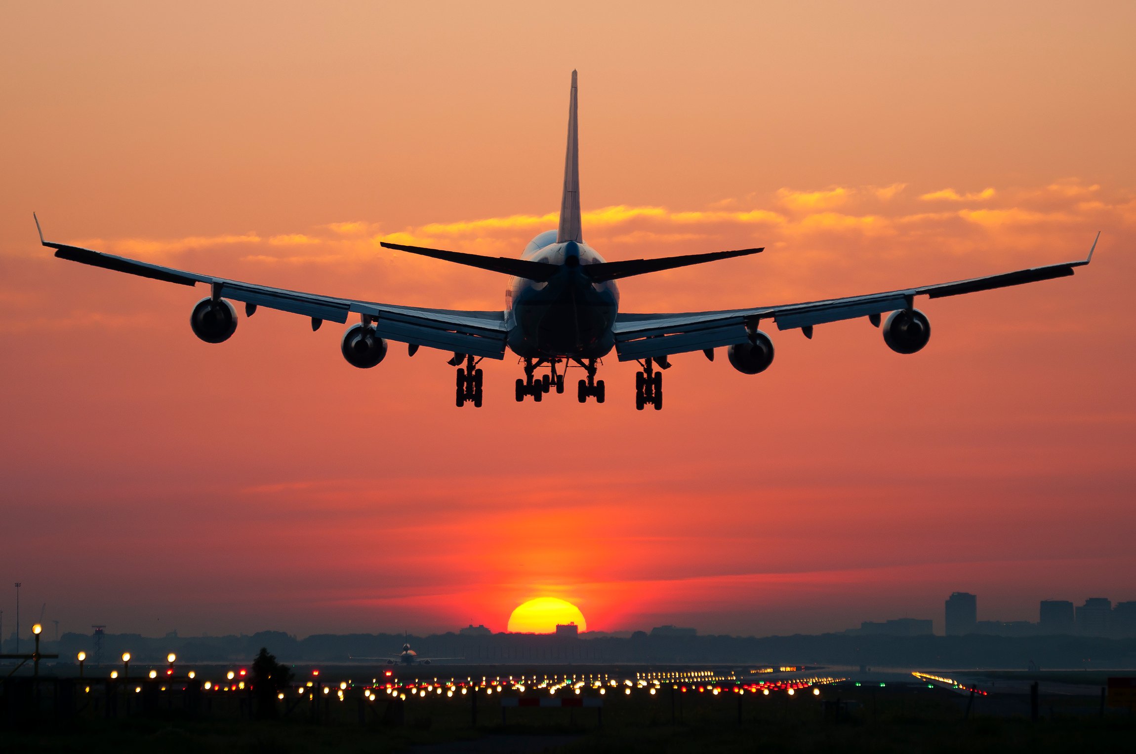 An airplane landing at sunset.