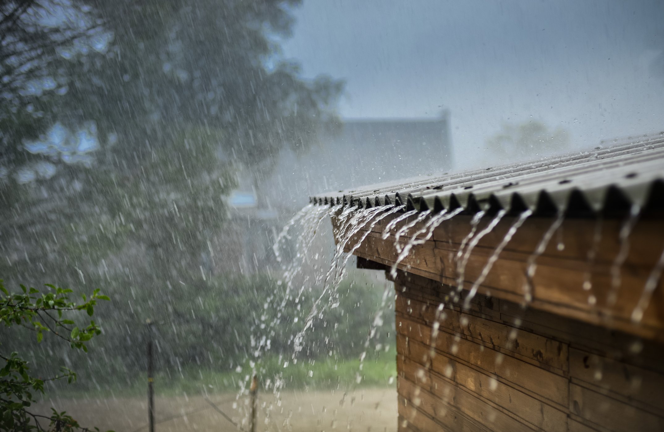 Water flowing off the roof of a building while it's raining.