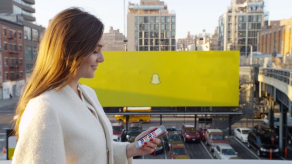Someone on the Snapchat app walking in front of a Snapchat billboard.