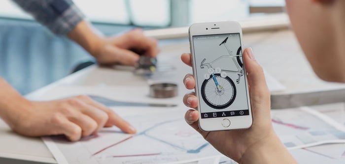 Bike designer using an iPhone to look at design specs.