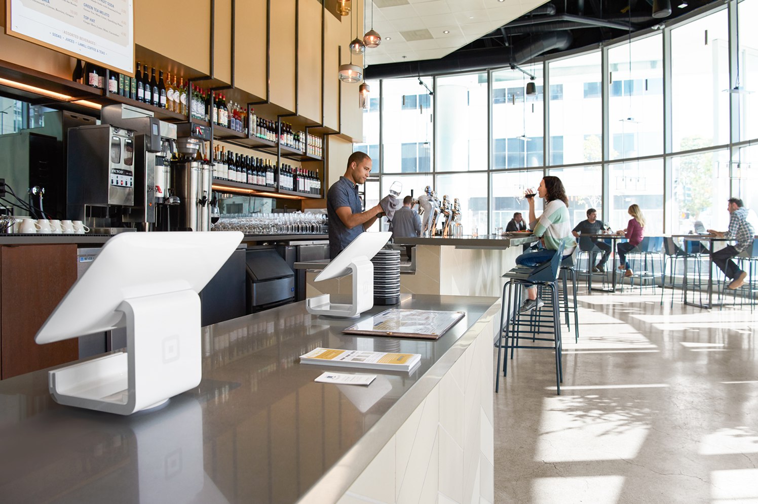 Restaurant counter with several Square pay terminals lined up. 