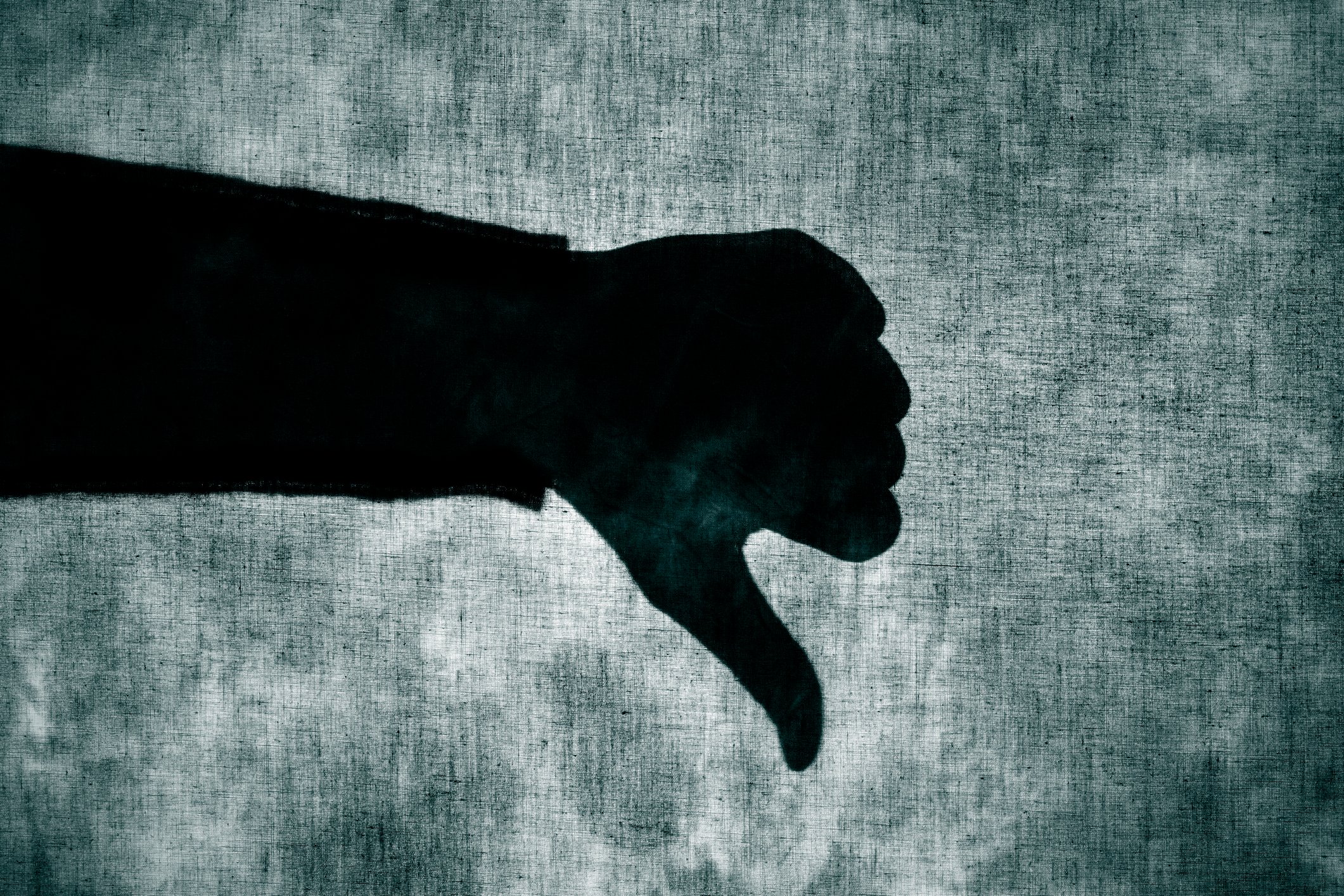 A shadow of a person giving a thumbs down signal.