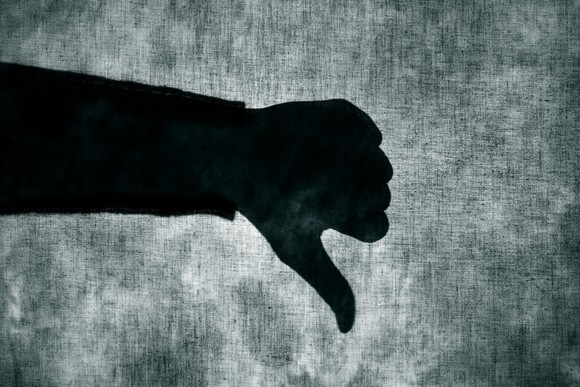 A shadow of a person giving a thumbs down signal.