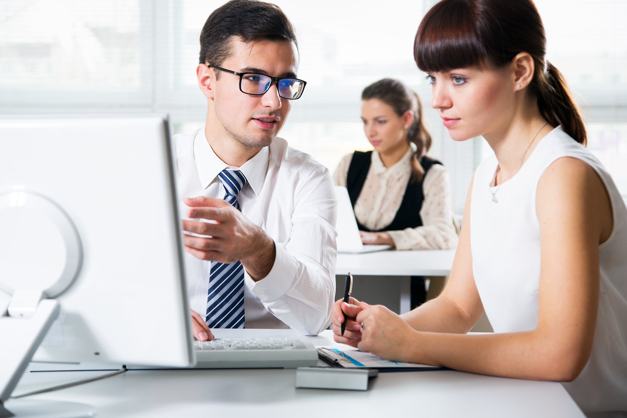 Man showing woman something on his computer screen