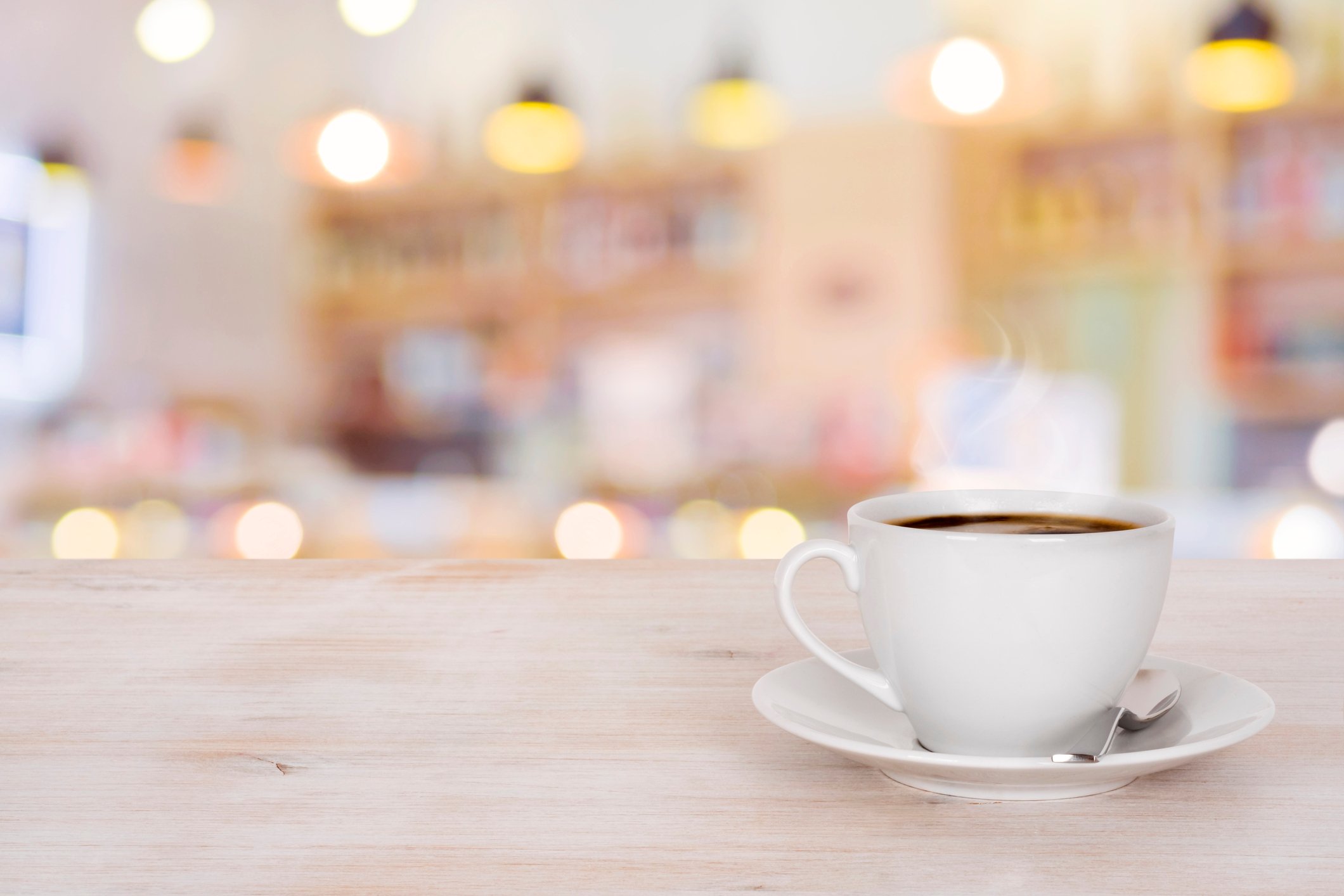 A cup of coffee sits on a table.