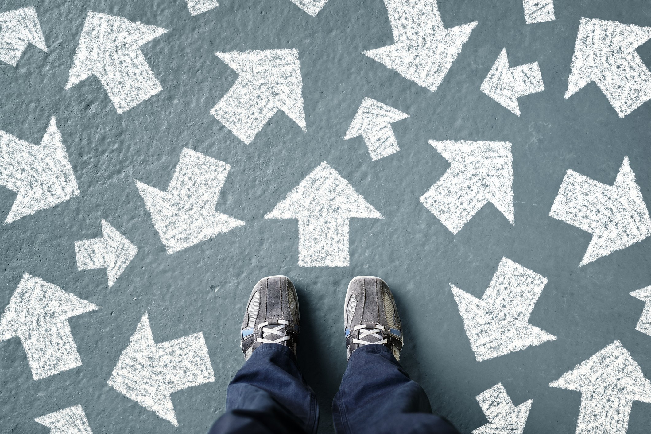 A camera looking down at a person's feet. There are white arrows pointing in random directions on the ground.