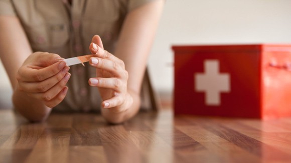 Woman applying a Band-Aid bandage to a wound