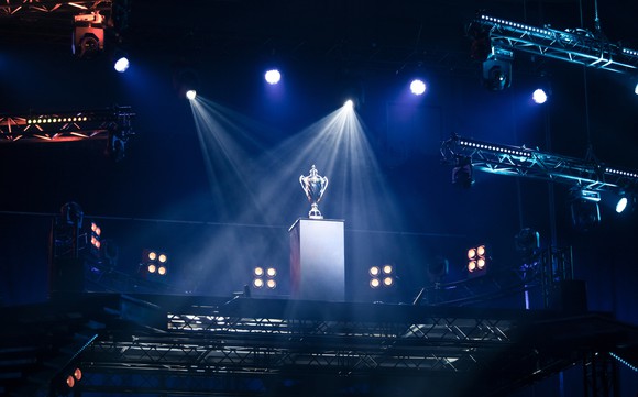 A trophy under spotlights on a stage.