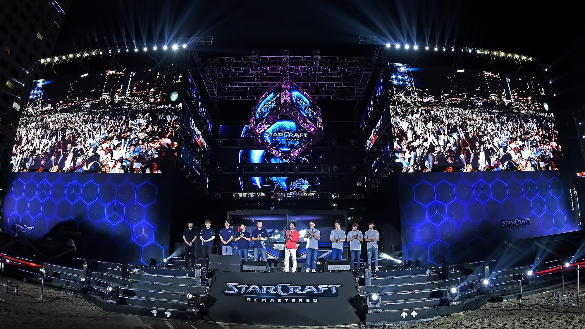 Two teams on a stage at a competitive "Starcraft" event.