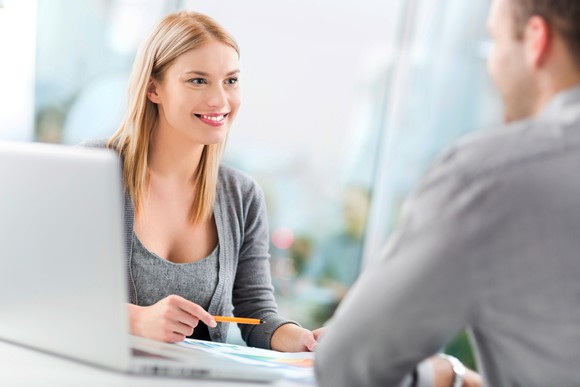 Two businesspeople working together over a laptop.