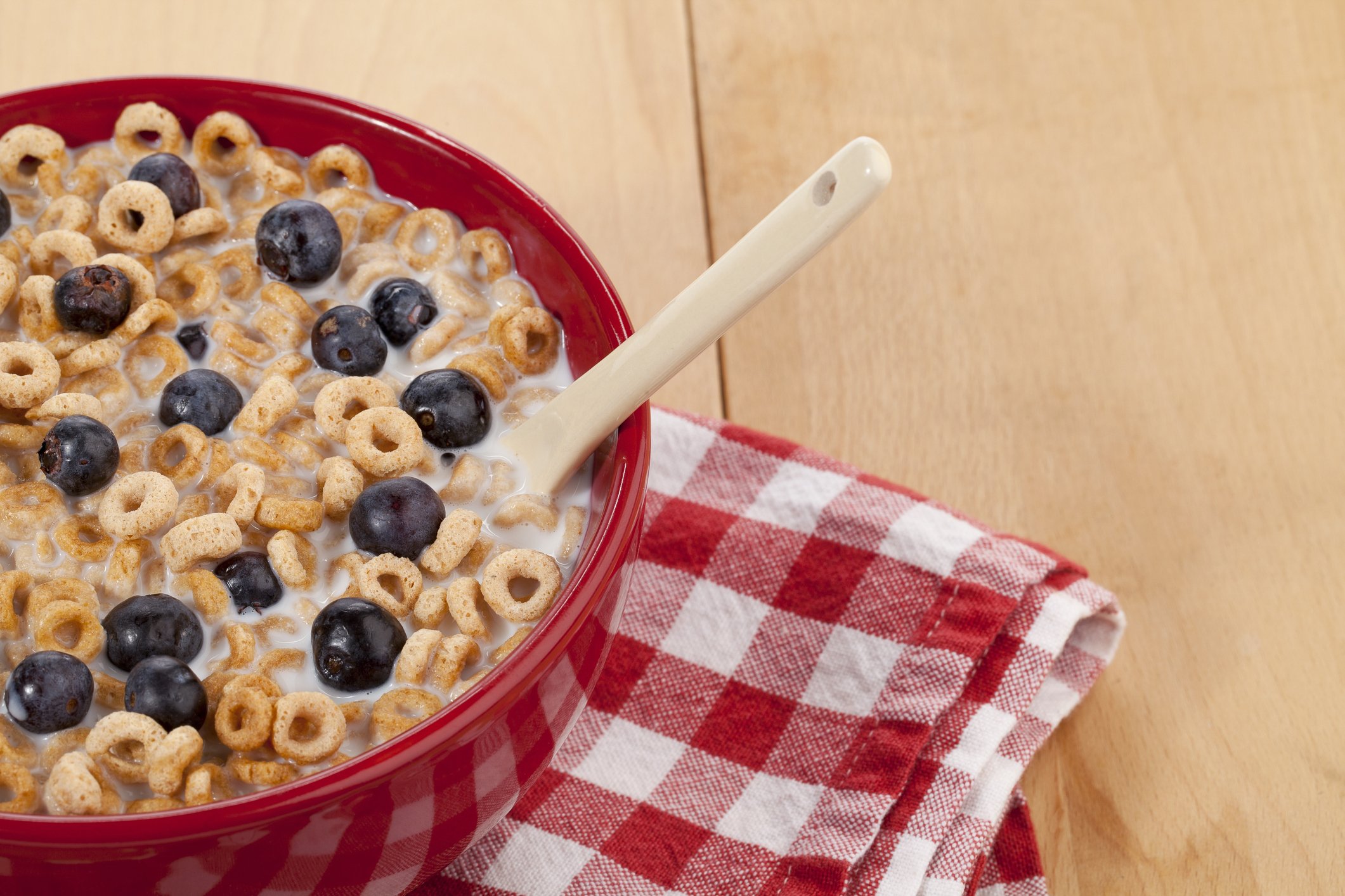 A bowl of cereal on a table with a napkin. 