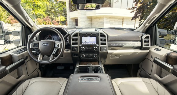 The interior of a 2018 Ford F-450 Limited, with leather seats, wood trim, and a touchscreen system visible.