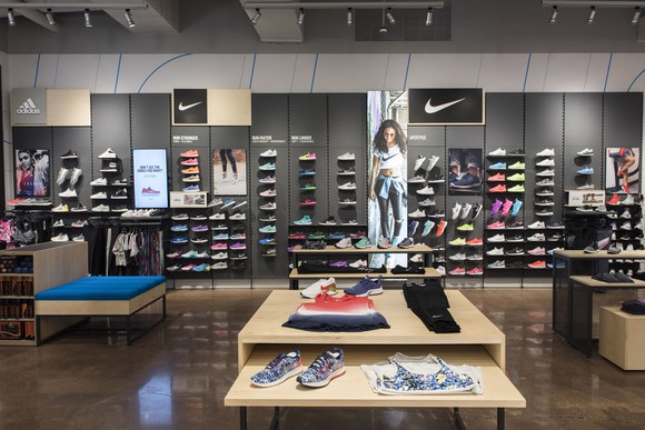 Interior of a Finish Line store with shoes lined up neatly on a wall display