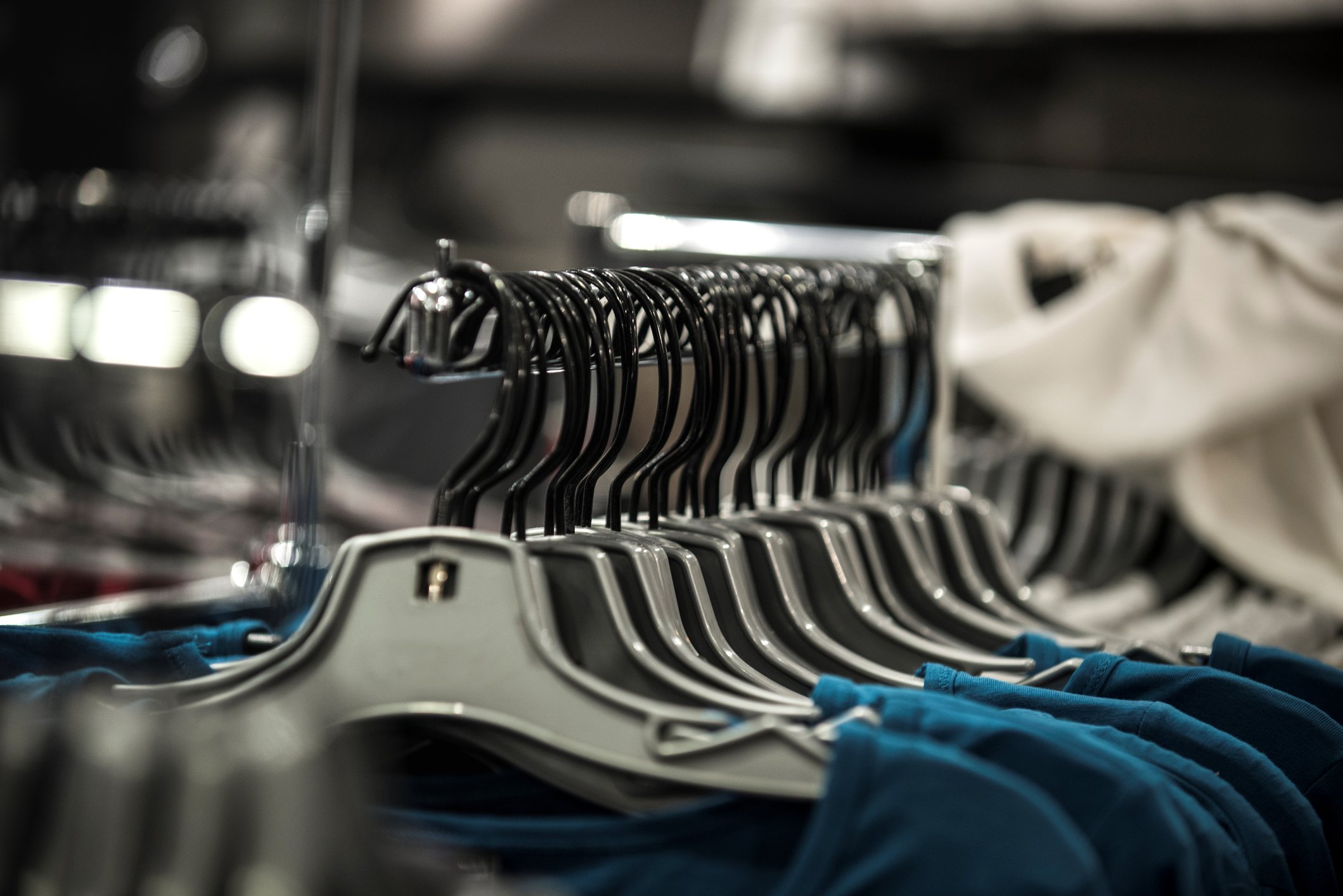 blue and white shirts hanging on a store display rack