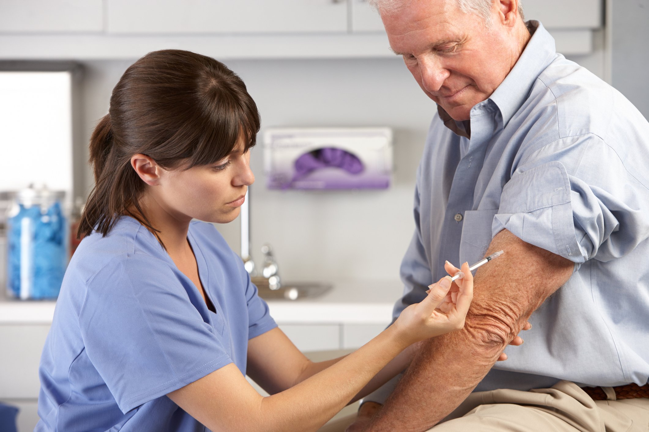 Man receiving an injection from a nurse.