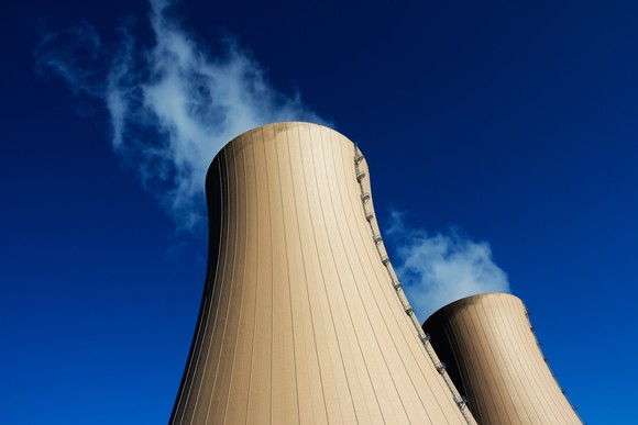 Two cooling towers shown against a clear blue sky.
