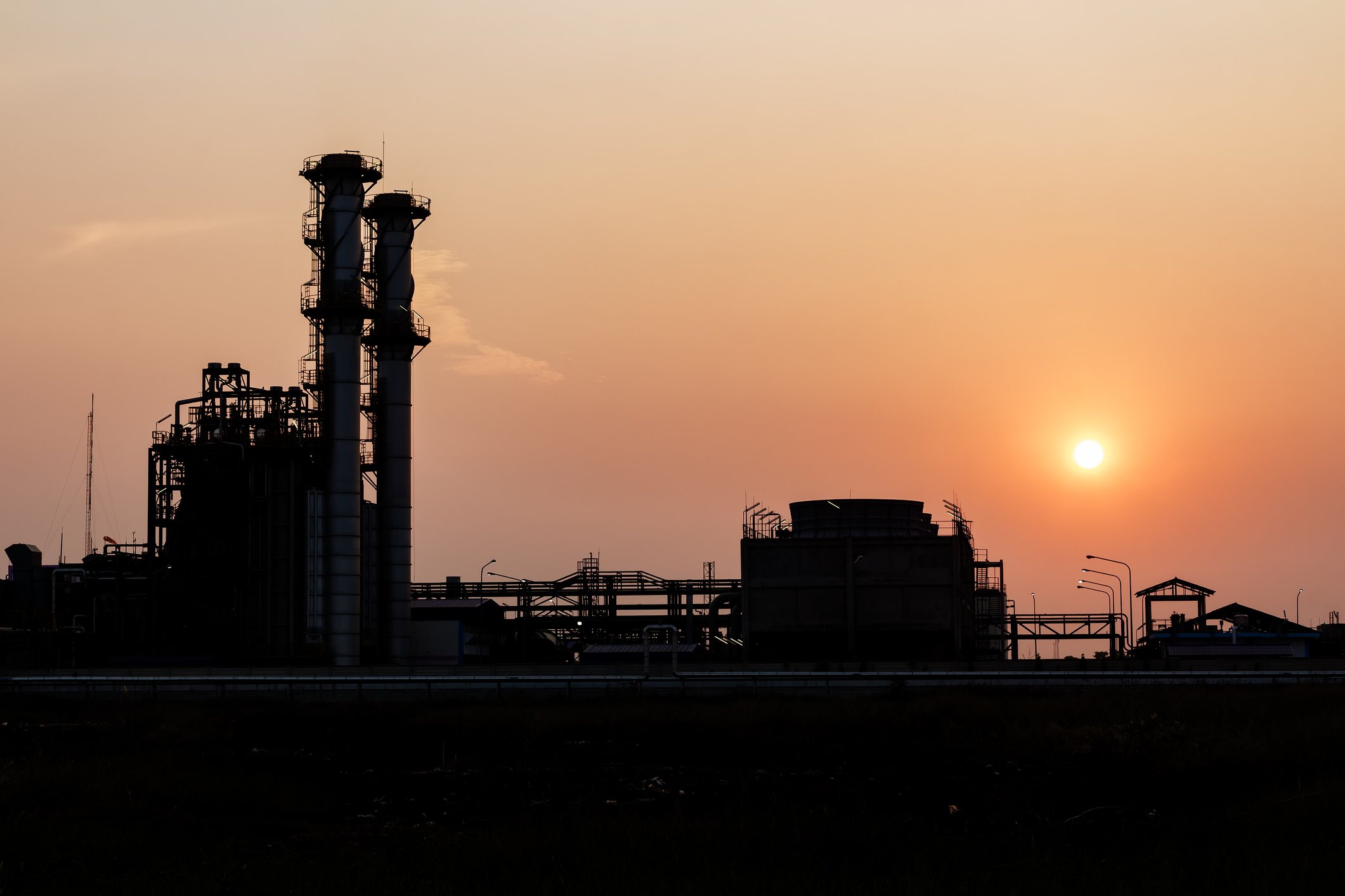 A refinery tower at sunset.