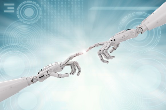 Two robot hands connecting at the fingertips.