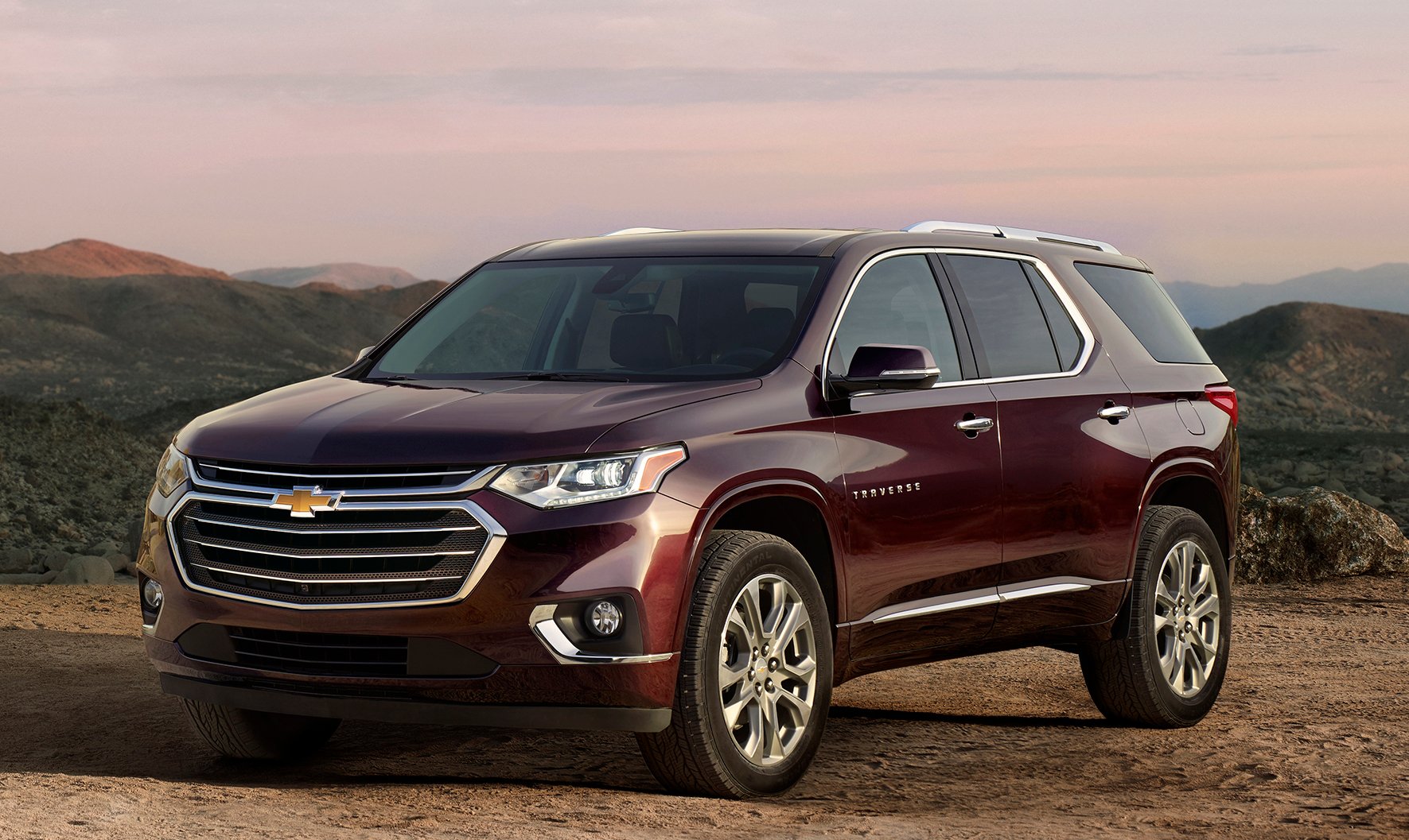 A wine-red 2018 Chevrolet Traverse crossover SUV parked with mountains in the background.