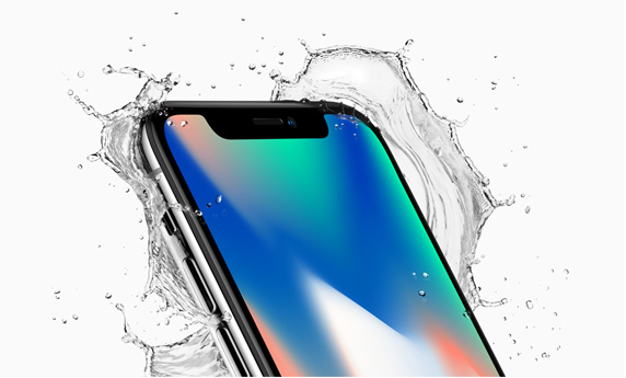 Apple's iPhone X shown with a splash of water to demonstrate that it's waterproof