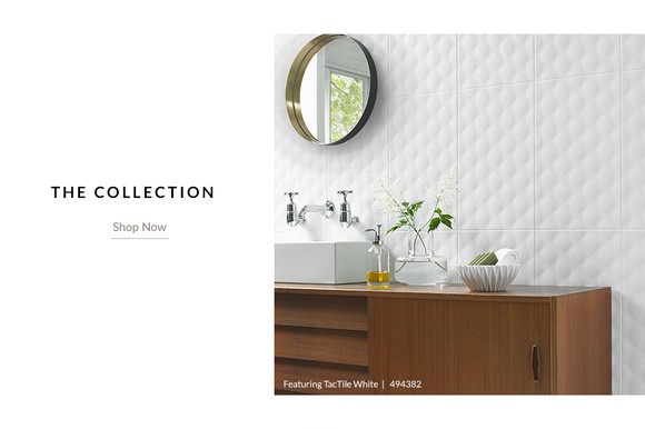 Bathroom with stylish wall tile, mirror, and cabinet.