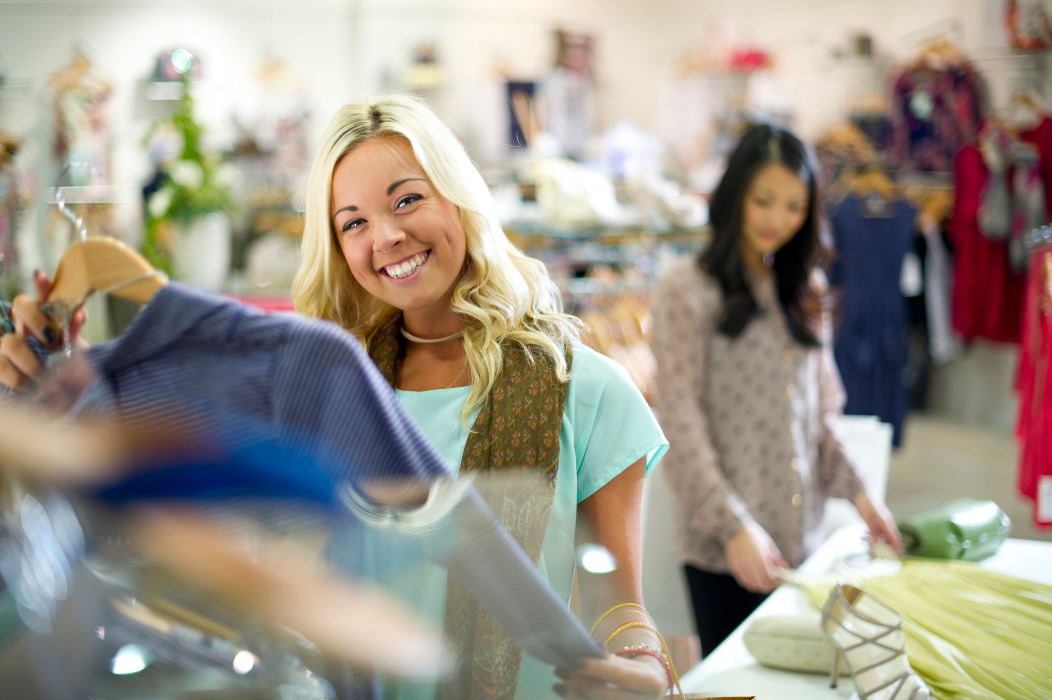 Two young women shop for clothes.