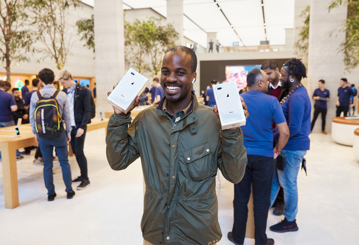A man holds two new iPhone 8 smartphones in their boxes