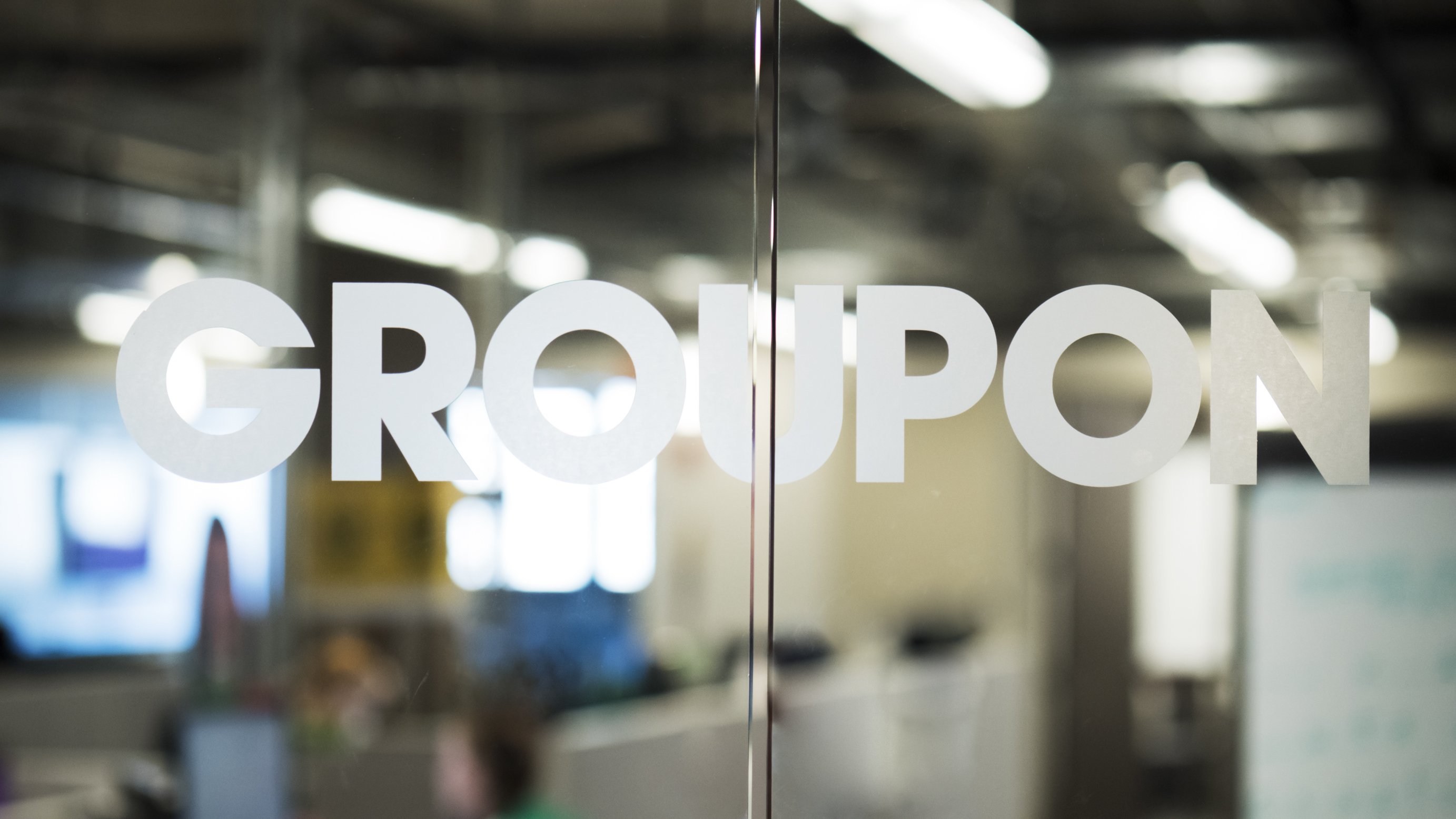 A Groupon logo on a glass office door.