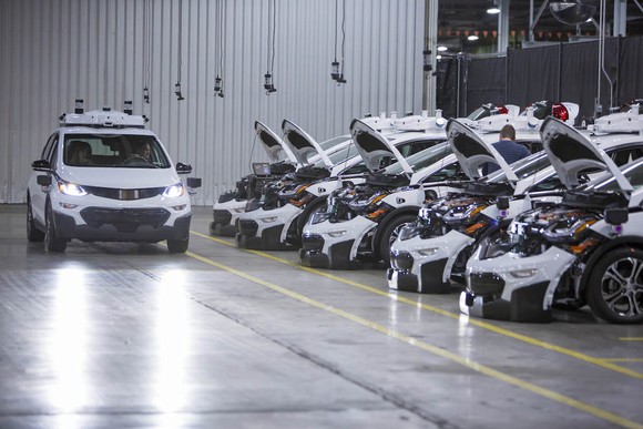 Image of GM cars with hoods open in a factory.