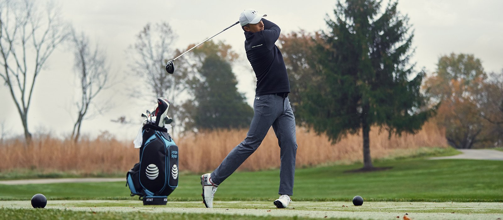 Golfer Jordan Spieth teeing off while wearing Under Armour gear