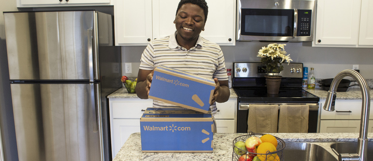 A young man holds a Wal-Mart box.