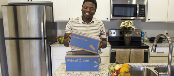 A young man holds a Wal-Mart box.