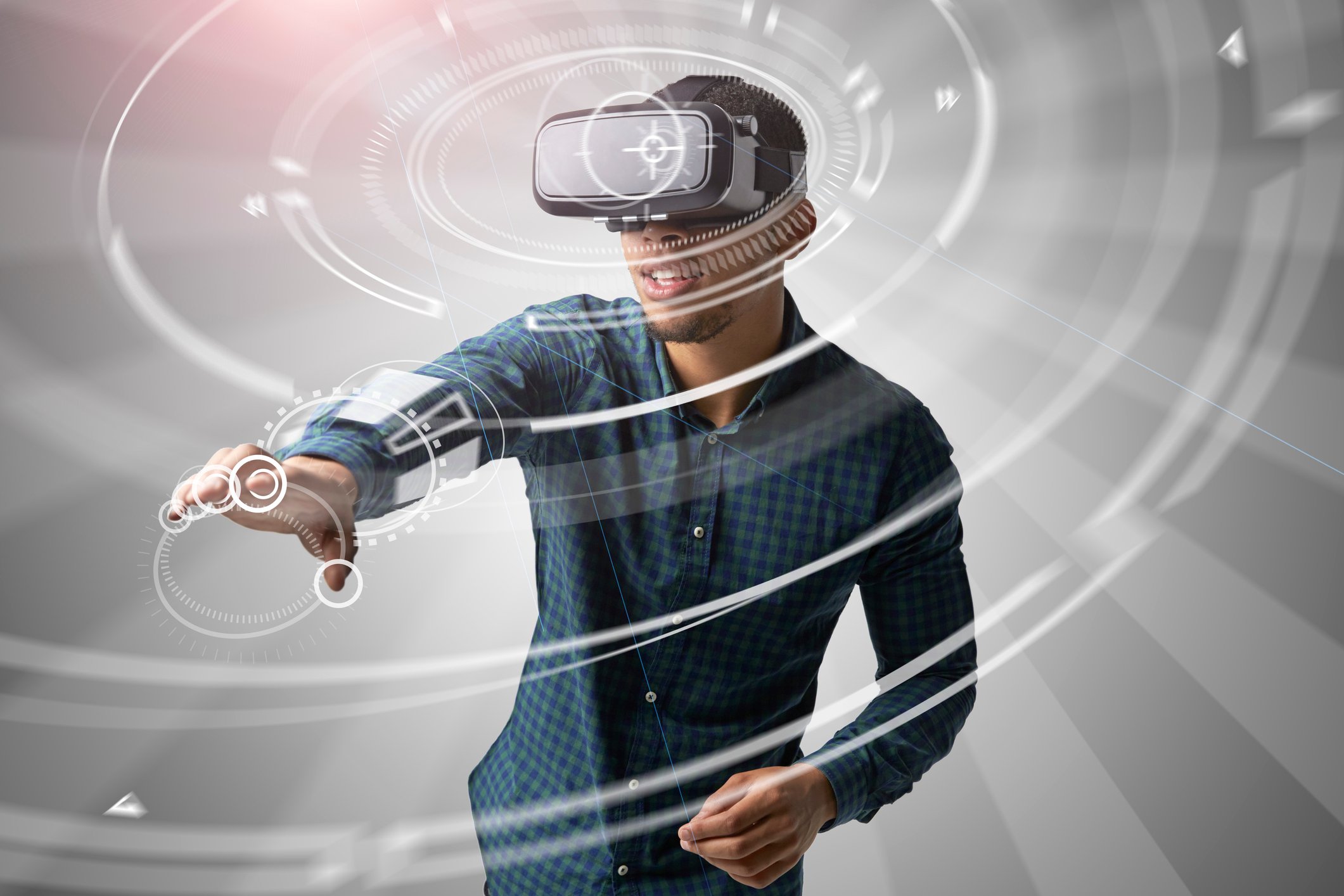 Man using VR with graphics of a glove on his hand overlaying the image. 