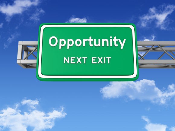 A green highway sign against a blue sky reads "opportunity next exit."