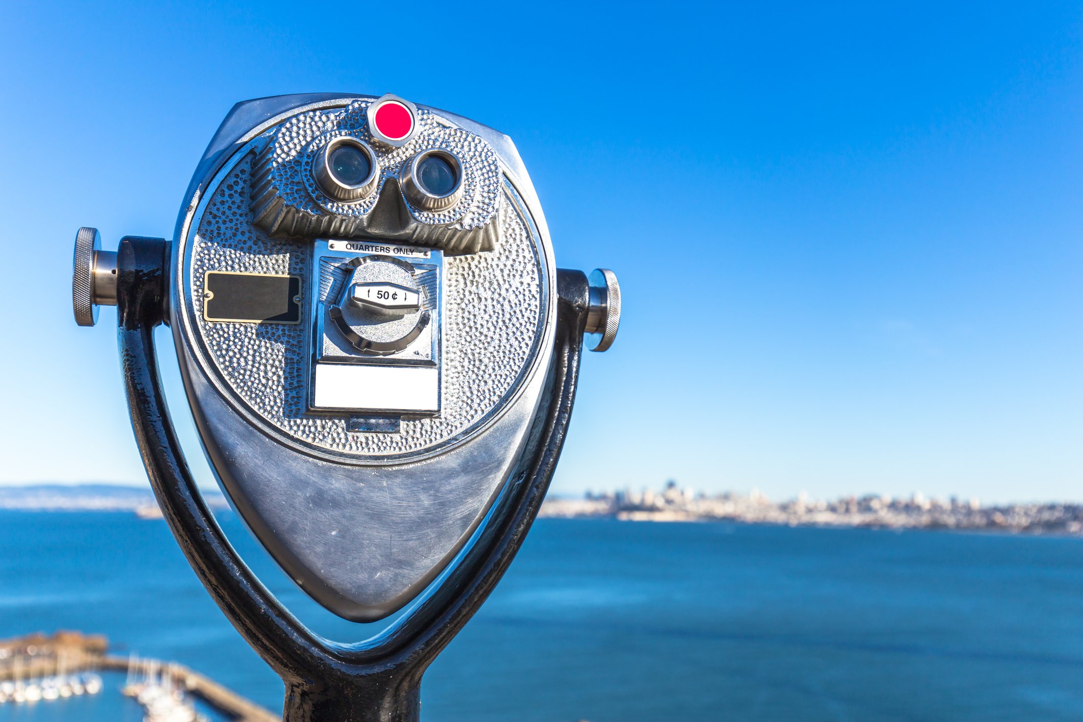 A coin-operated scope looks out on a body of water.