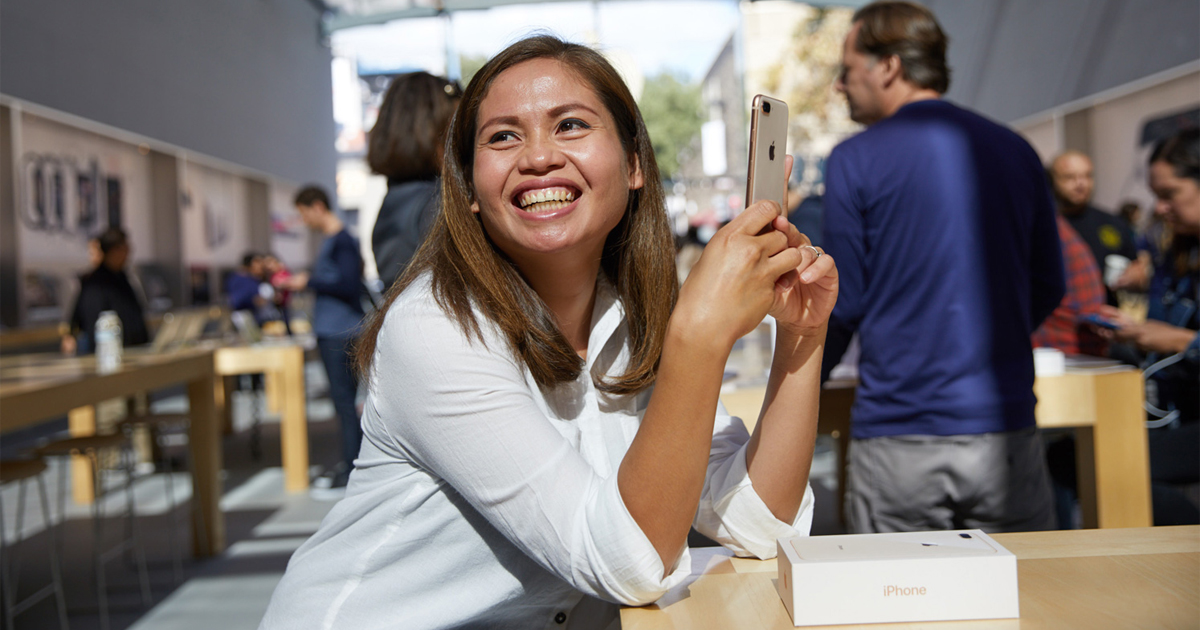 A person in an Apple store with an iPhone 8.