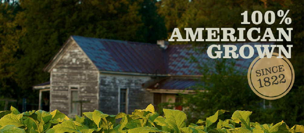 Older farm house with tobacco growing in foreground and logo "100% American Grown Since 1822."