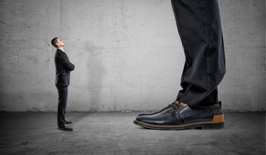 Tiny businessman looking up at giant businessman