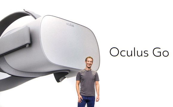 Mark Zuckerberg standing on stage with a picture of Oculus Go behind him